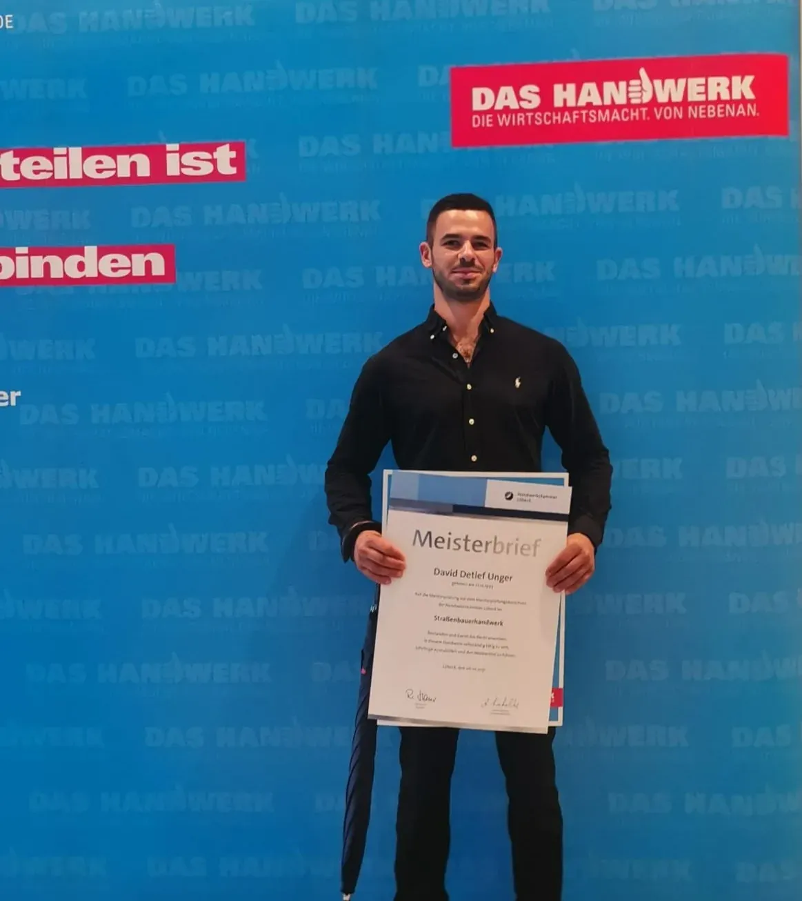 David Unger mit seinem Meisterbrief im Straßenbauerhandwerk